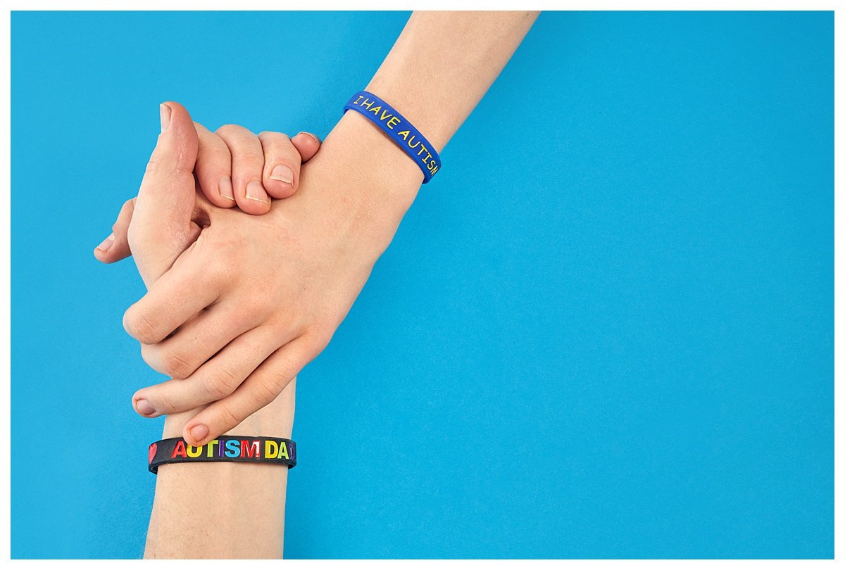 Autism Awareness. Autism father holding hand his Autistic Child with I have autism bracelet.